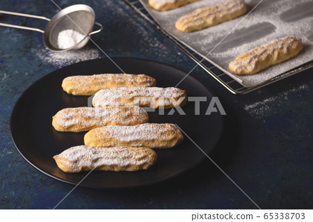 Savoyardi cookies sprinkled with powdered sugar on blue 65338703