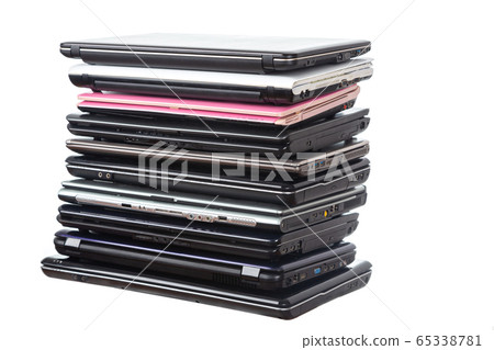 Stack of used laptops in different colors and 65338781