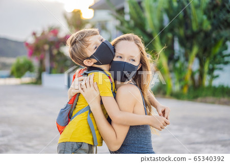 mom hugs a sad son on the sidewalk in the city. Mother and baby wear face mask during coronavirus mom hugs a sad son on the sidewalk in the city. Mother and baby wear face mask during coronavirus 65340392
