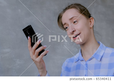 Woman using smartphone, having video chat, interview or consultation 65340411