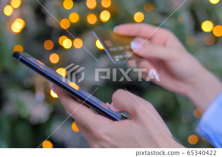 Woman using smartphone and credit card for online shopping. Christmas background Woman using smartphone and credit card for online shopping. Christmas background 65340422