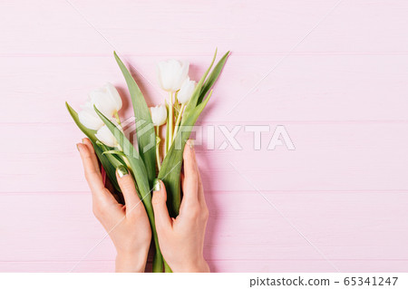 Female's hands holding bouquet of fresh tulip 65341247