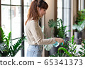 Young Asian woman water plant in room. Botanist shop owner happy smiling working success in business 65341373