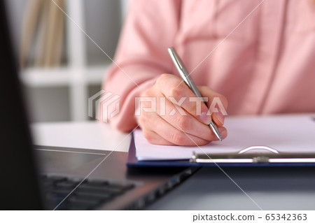 Closeup, female hands taking notes with pen office 65342363