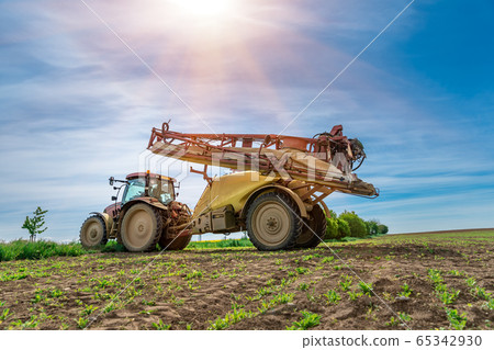tractor with a sprayer for plants in the field 65342930