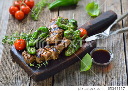 Grilled vegan seitan steaks with pimientos and a herb soy dip sauce on a rustic wooden background Grilled vegan seitan steaks with pimientos and a herb soy dip sauce on a rustic wooden background 65343137