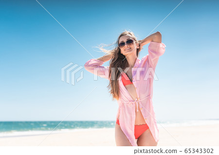Carefree woman on the beach 65343302