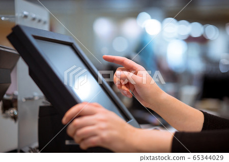 Young woman hand doing process payment on a touchscreen cash register, POS, finance concept 65344029