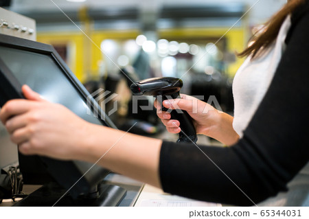 Young woman hands scaning, entering discount, sale on a receipt, touchscreen cash register, POS, finance concept Young woman hands scaning, entering discount, sale on a receipt, touchscreen cash register, POS, finance concept 65344031