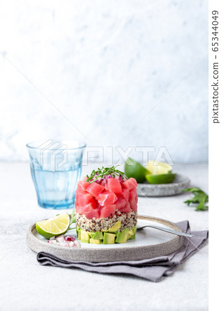 Tuna tartare tartar with avocado and quinoa. gourmet presentation with culinary ring on wite plate 65344049