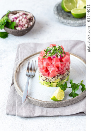 Tuna tartare tartar with avocado and quinoa. gourmet presentation with culinary ring on wite plate 65344051