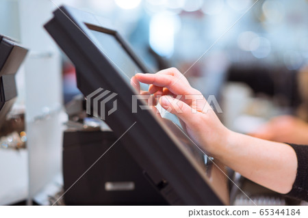 Young woman hand doing process payment on a touchscreen cash register, POS, finance concept Young woman hand doing process payment on a touchscreen cash register, POS, finance concept 65344184