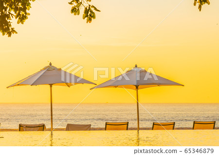 Beautiful tropical outdoor beach sea ocean with umbrella and chiar around outdoor swimming pool at sunset or sunrise time Beautiful tropical outdoor beach sea ocean with umbrella and chiar around outdoor swimming pool at sunset or sunrise time 65346879