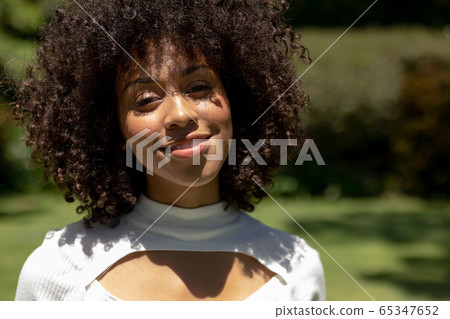 Woman looking to camera in the garden Woman looking to camera in the garden 65347652