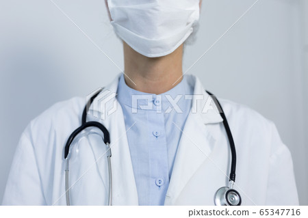 Healthcare worker wearing protective suit and face mask during coronavirus Covid19 pandemic 65347716
