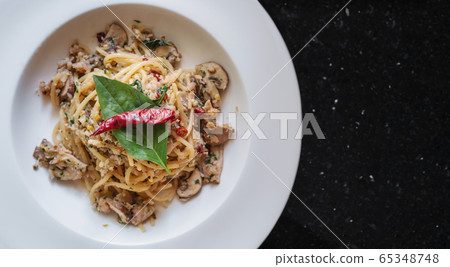 Stir fry Spaghetti with salted fish, Thai spices and dry chili, in white dish Stir fry Spaghetti with salted fish, Thai spices and dry chili, in white dish 65348748