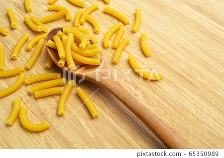 Raw fresh and healthy macaroni pasta on wooden 65350989
