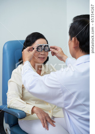 Ophthalmologist testing eyesight Ophthalmologist testing eyesight 65354167