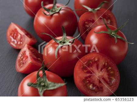 Tomatoes placed on black stone background 65356123