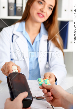 Alcoholic hold in arm empty bottle and medication Alcoholic hold in arm empty bottle and medication 65356152