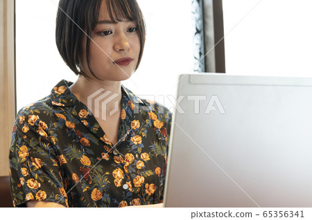 A woman at a table with a laptop A woman at a table with a laptop 65356341