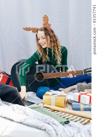 Woman practicing Christmas song 65357741