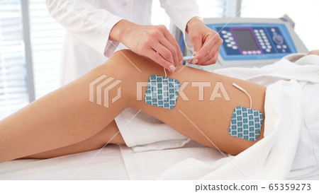 session of myostimulation on women's legs in a cosmetology clinic session of myostimulation on women's legs in a cosmetology clinic 65359273