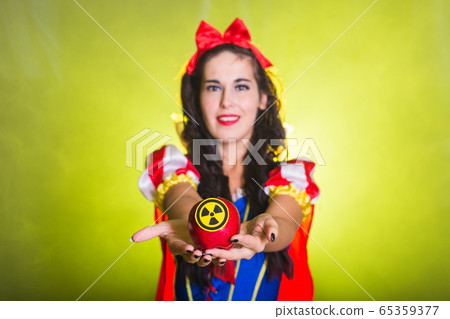 Woman wearing a fairy tale dress holding an apple with radiation symbol. Environmental problems concept, radioactive disaster as danger on nature. Woman wearing a fairy tale dress holding an apple with radiation symbol. Environmental problems concept, radioactive disaster as danger on nature. 65359377