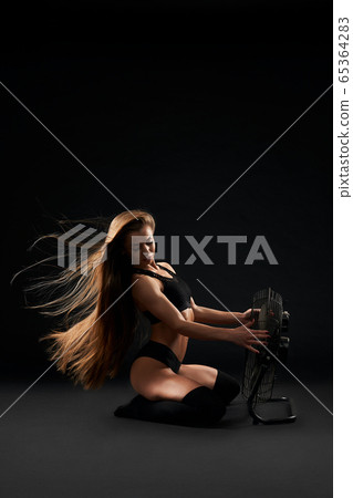Model posing on floor with fen. Model posing on floor with fen. 65364283