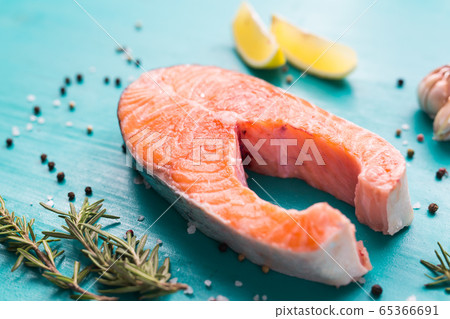 Salmon with lemon, pepper and rosemary on blue background. Keto diet, pescetarianism and healthy food concept. 65366691