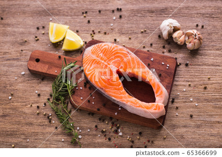 Raw salmon steak on wooden board top view. Healthy food, diet and mediterranean cuisine concept Raw salmon steak on wooden board top view. Healthy food, diet and mediterranean cuisine concept 65366699