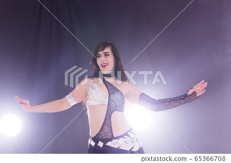 Young woman dancing in Tribal Fusion style. Belly dance on the stage. Young woman dancing in Tribal Fusion style. Belly dance on the stage. 65366708