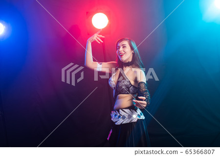 Girl dancing belly dance, fusion or tribal. A woman in a beautiful costume demonstrates charming and gentle movements in the dance. 65366807