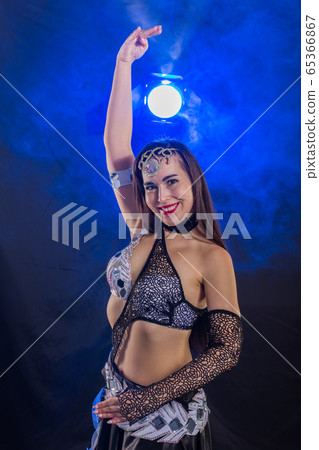 Spirituality dance. Beautiful sexy woman with luxury glossy eastern make-up dancing tribal fusion. Belly dance. 65366867