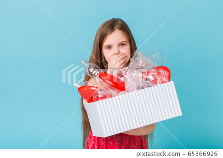 Environmental protection and pollution concept. Surprised child carrier box with plastic trash over blue background. Environmental protection and pollution concept. Surprised child carrier box with plastic trash over blue background. 65366926