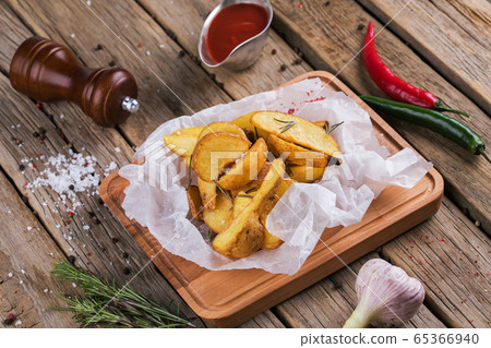 Baked potato wedges with herbs and ketchup decorated with dill. Baked potato wedges with herbs and ketchup decorated with dill. 65366940