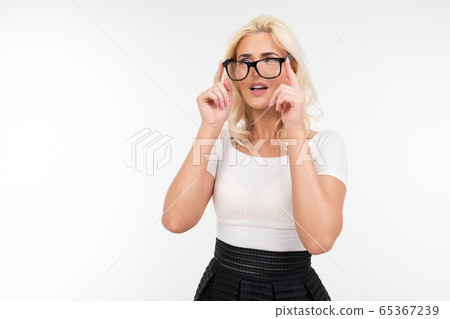 girl is uncomfortable wearing glasses for vision on a white studio background with copy space 65367239