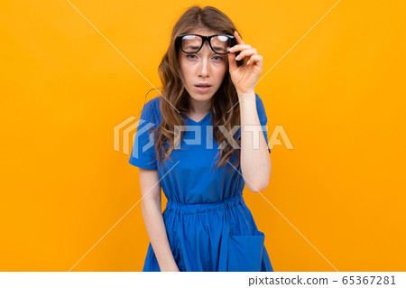 close-up of a girl with glasses with eyes closed on a yellow studio background close-up of a girl with glasses with eyes closed on a yellow studio background 65367281