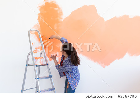 Dancing funny woman with painting roller indoors. Redecoration, renovation, apartment repair and refreshment concept. Dancing funny woman with painting roller indoors. Redecoration, renovation, apartment repair and refreshment concept. 65367799