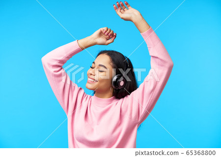Pretty black girl dancing listening music with her headphones Pretty black girl dancing listening music with her headphones 65368800