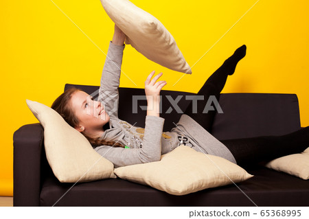 girl sits at home on the couch with pillows girl sits at home on the couch with pillows 65368995