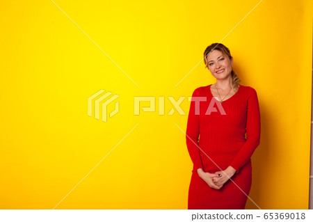 woman forty years in a dress on a yellow background 65369018