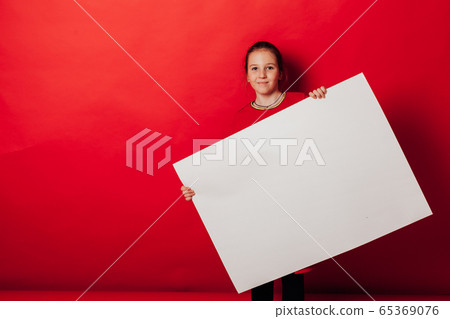 Schoolgirl's girl holds sign for inscriptions on red background Schoolgirl's girl holds sign for inscriptions on red background 65369076