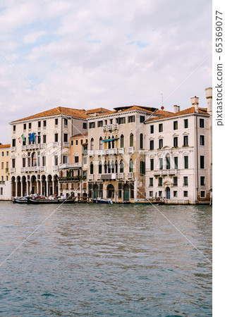 Old houses on Grand Canal, Venice, Italy. Vintage hotels and residential buildings in the Venice center. Historical architecture of Venice on water in summer. Venetian street with ancient facades. Old houses on Grand Canal, Venice, Italy. Vintage hotels and residential buildings in the Venice center. Historical architecture of Venice on water in summer. Venetian street with ancient facades. 65369077