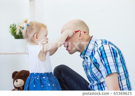 Funny baby toddler girl playing in living room. Children and family concept. 65369625