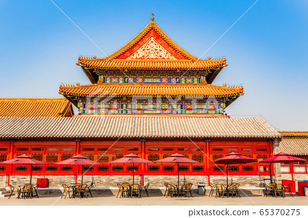 Summer cafe with tables and umbrellas at the wall 65370275