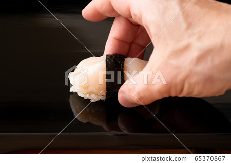 Itamae holding the scallop sushi Itamae holding the scallop sushi 65370867