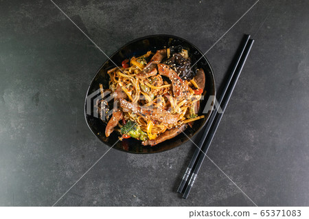 Asian noodles with meat on plate 65371083