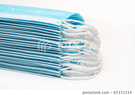 Stack blue surgical medical face masks with rubber ear straps on white background. Close-up view, forced perspective Stack blue surgical medical face masks with rubber ear straps on white background. Close-up view, forced perspective 65371314