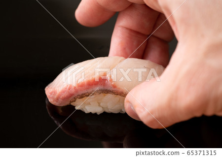 Itamae holding amberjack sushi 65371315